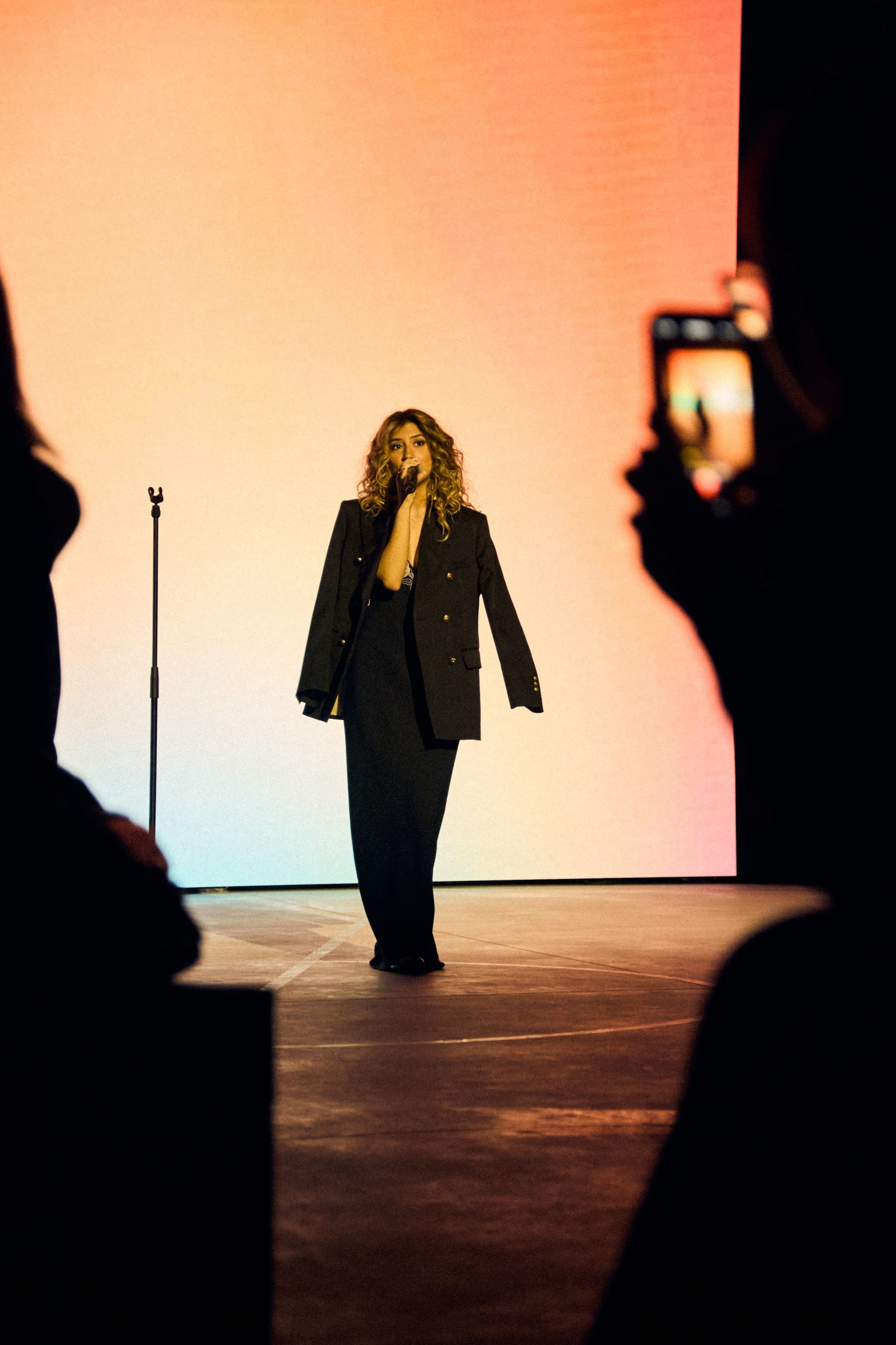 Female singer performing in front of gradient lit backdrop during Venice Haus event