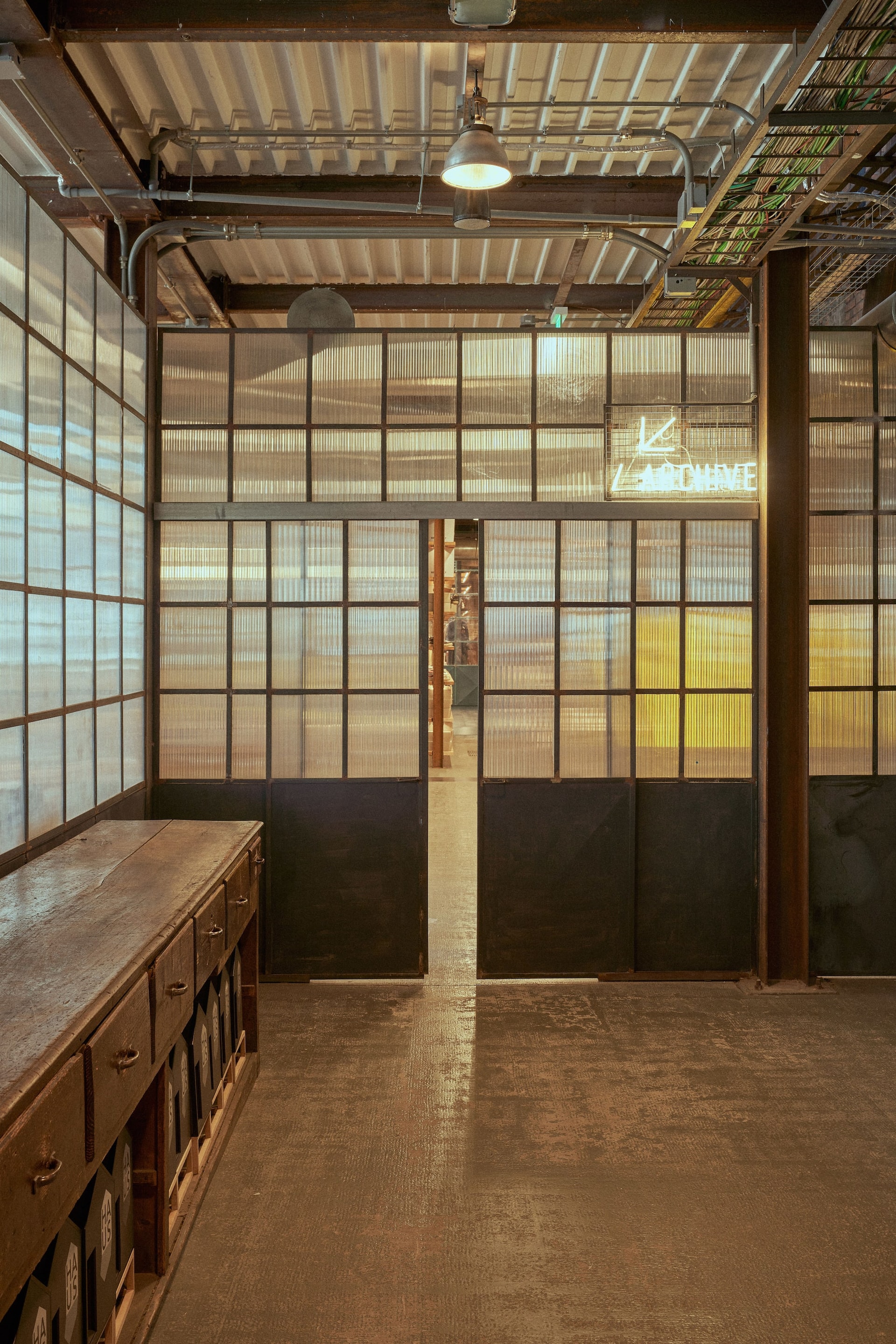 Translucent archive sliding doors in industrial space with vintage wooden cabinets in Venice Haus