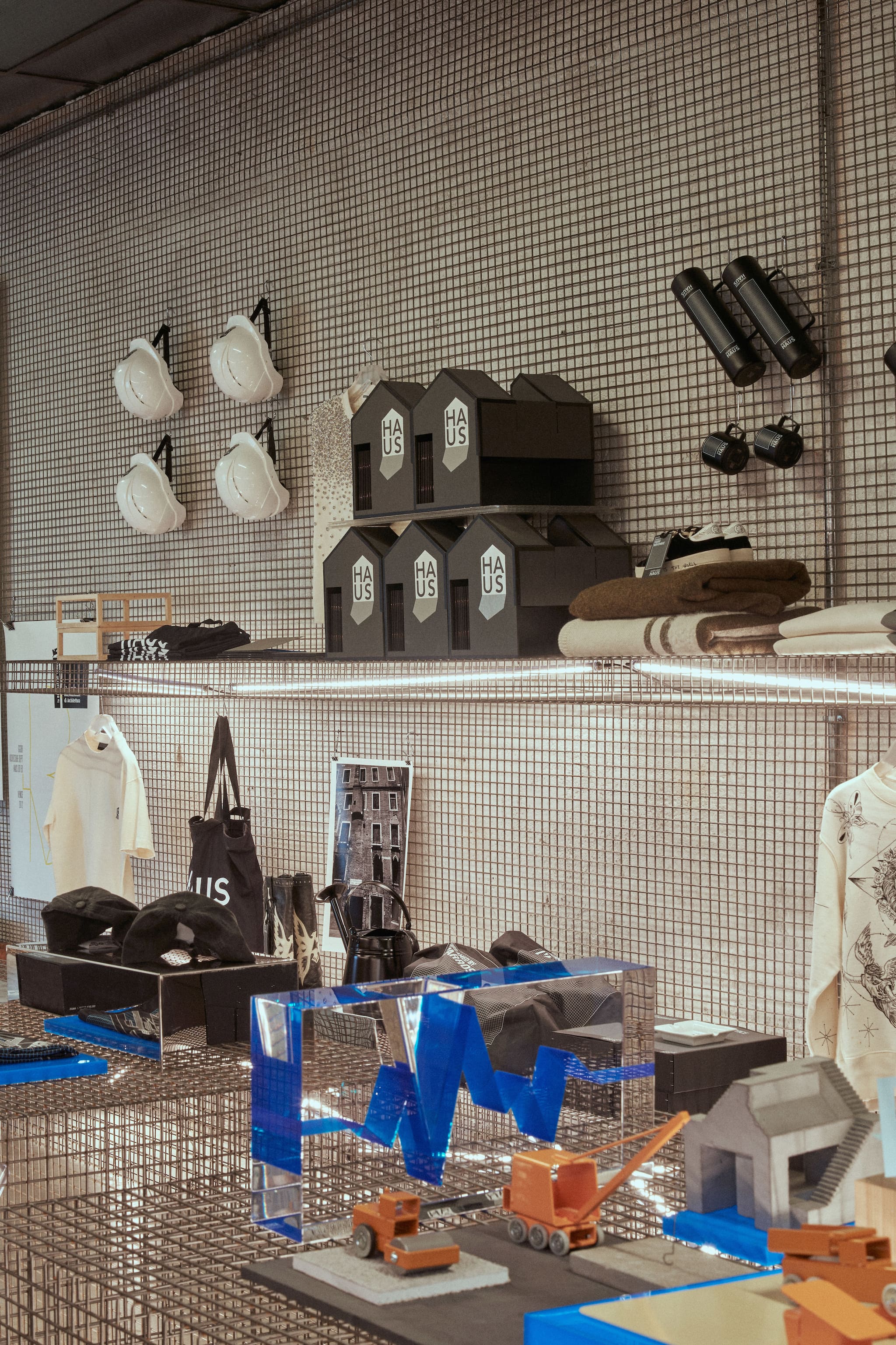 Wire mesh shelves displaying merchandise and blue acrylic logo sculpture at Venice Haus location