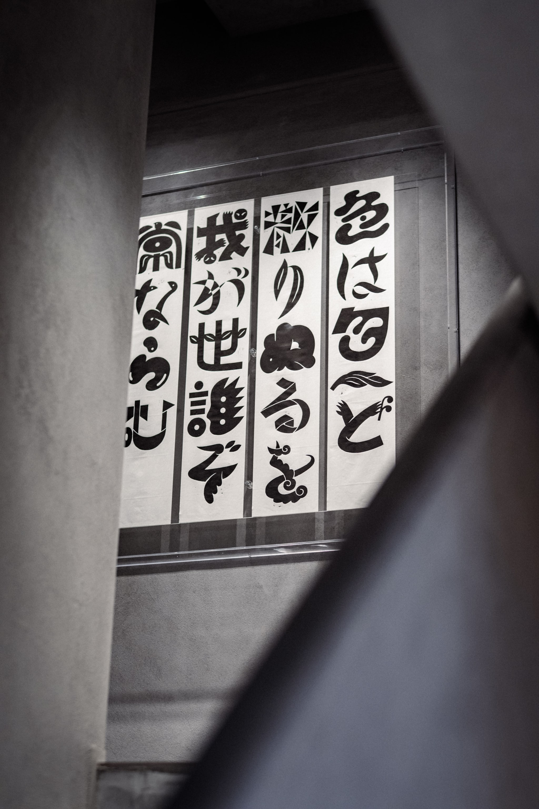Japanese calligraphy banners displayed vertically on wall at Tokyo Haus location